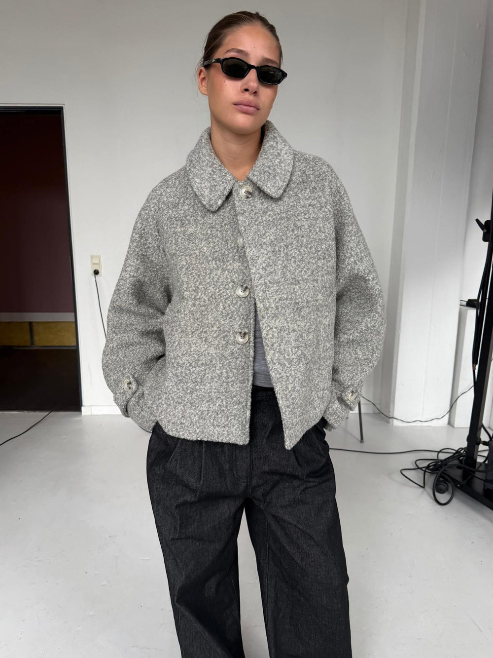 A model wearing a stylish gray MEOTINE jacket with a collared neckline, paired with black wide-leg pants and sunglasses.