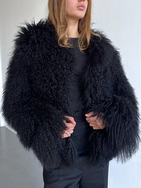 A model showcases a luxurious black fluffy coat with voluminous sleeves, exuding elegance and warmth, perfect for winter. MEOTINE.