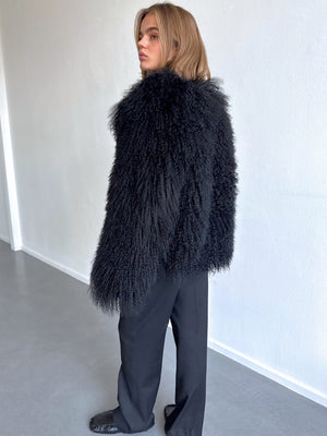 A model showcases a stylish black fluffy jacket paired with sleek black pants, embodying MEOTINE's chic aesthetic.