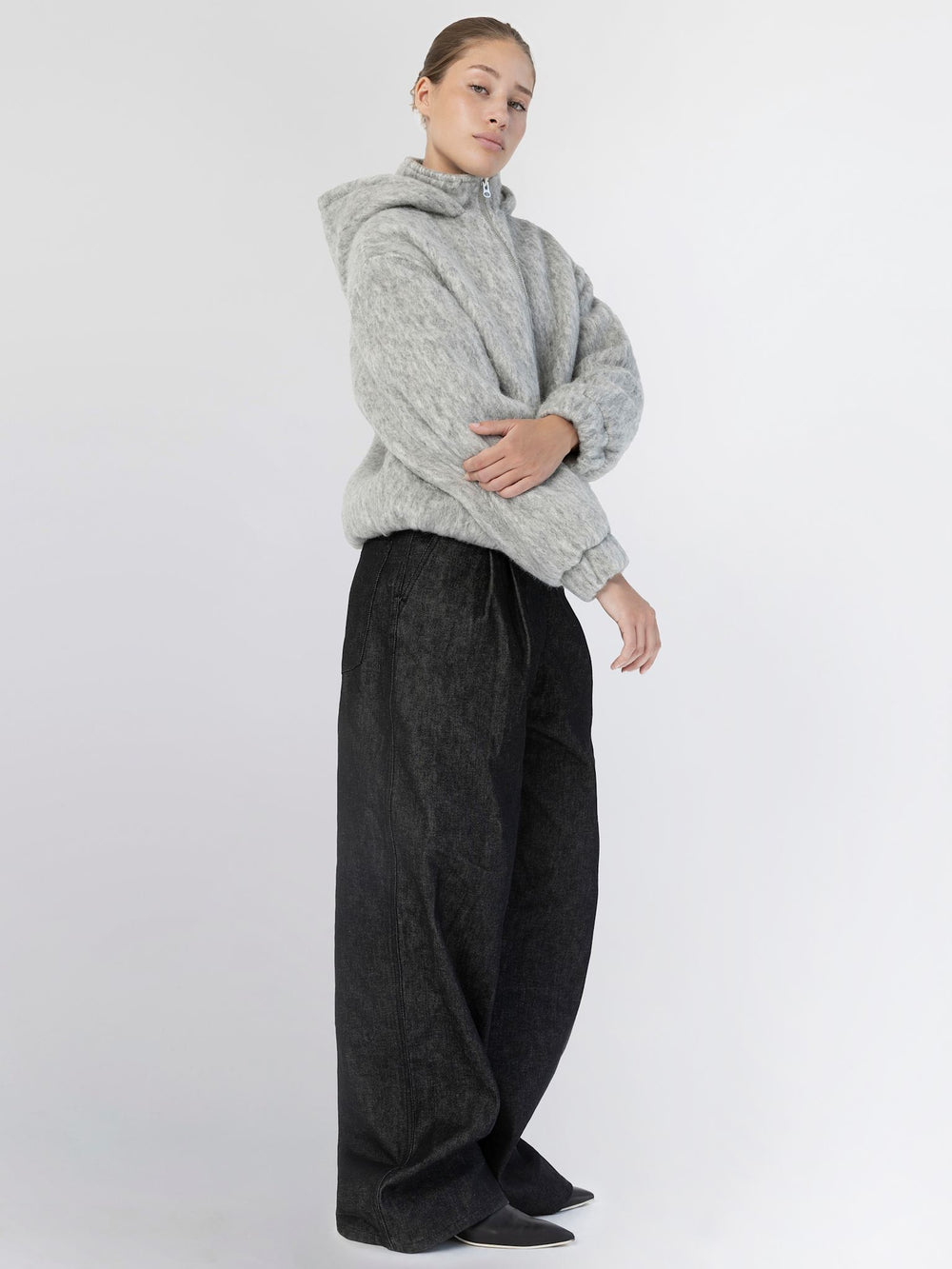 A model wears a cozy gray hoodie and wide-leg black pants, showcasing a stylish and comfortable look by MEOTINE.