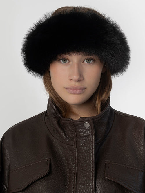 A model wears a stylish black fur hat paired with a brown leather jacket, showcasing MEOTINE's chic winter fashion.