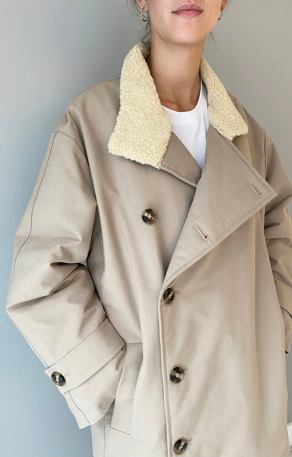 Stylish beige coat with a cozy shearling collar, perfect for a chic look. Designed by MEOTINE for comfort and elegance.