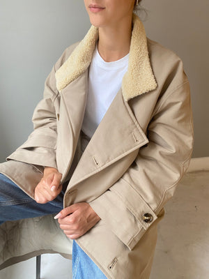 Cozy beige MEOTINE coat with a soft shearling collar, styled over a white t-shirt, perfect for a chic, casual look.