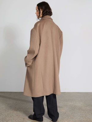 A model showcases a stylish oversized beige coat from MEOTINE, featuring a relaxed fit and elegant design, perfect for layering.
