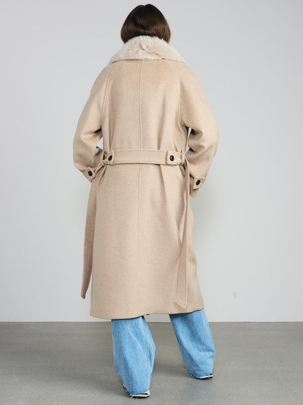 A model wearing a beige coat with a fur collar and a belt, paired with light blue wide-leg jeans, showcasing MEOTINE's elegant style.