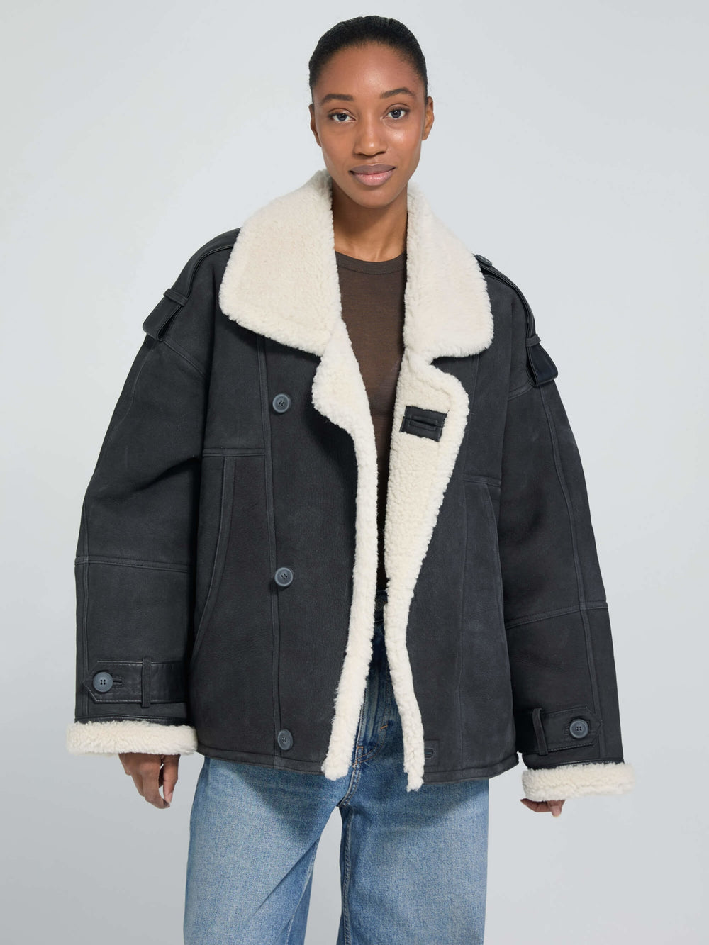 A model wears a stylish black MEOTINE jacket with a cozy white shearling collar, showcasing a relaxed fit and button details.